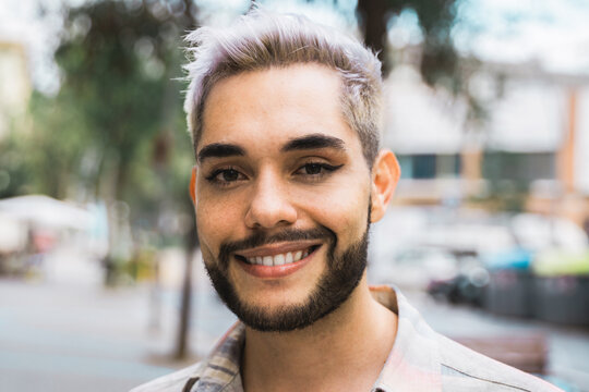 Young androgynous or nonbinary person smiling at camera - Diversity and equality community concept