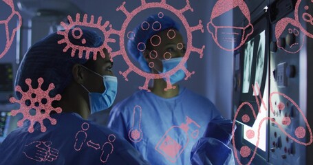 Examining 2 female staff reviewing monitor in procedure room wearing surgical PPE with pink overlay