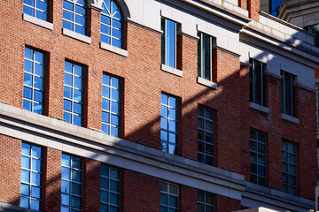 Obraz premium A close-up of elegant European-style architecture on Tianjin's Jiefang North Road is bathed in soft sunlight, highlighting the intricate stonework, arched windows, and timeless colonial charm.