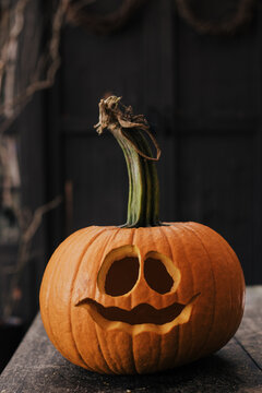 halloween pumpkin on a wooden table carved for a halloween party in October.