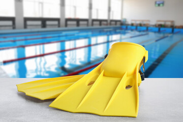 Swimming lesson. Yellow flippers by swimming pool © New Africa