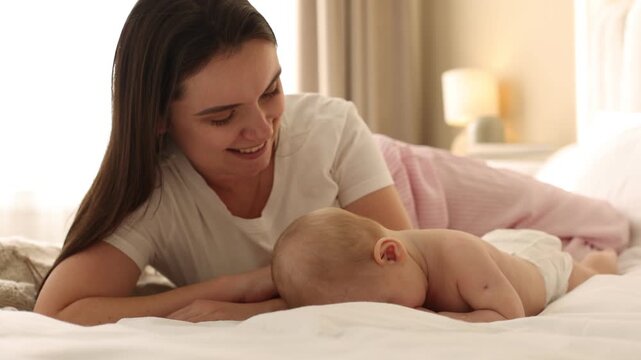 Mother and her cute baby on bed at home