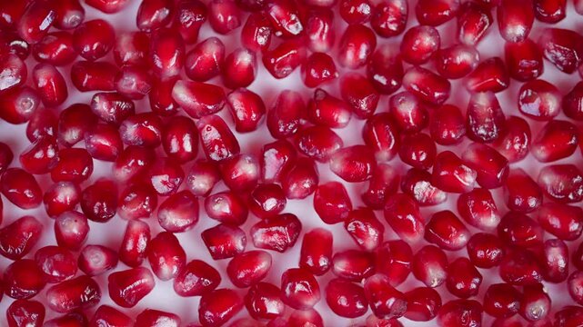 Vibrant pomegranate seed arrangement. Closeup of juicy pomegranate arils on background. Highcontrast shot highlighting intricate texture and freshness of pomegranate seeds