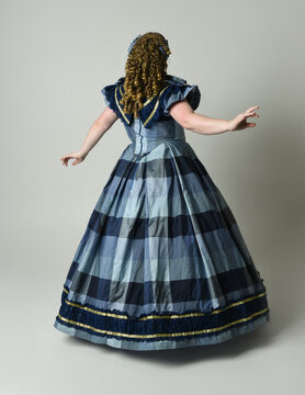 Victorian Era Woman in historical victorian classical Blue Ball Gown, Plus Size Model, full length Back View pose walking away. isolated figure on studio background.