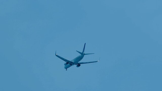 Low-angle view of a Utair Boeing 737-800 commercial passenger jet flying in a clear blue sky. The aircraft is on its final approach to Vnukovo International Airport (VKO) with landing gear deployed