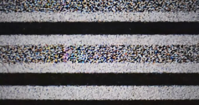 Close-up view of static noise on a television screen, showcasing colorful pixelation and distortion