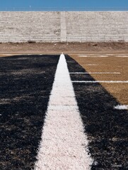 Obraz premium American football field turf with white yard line markings and stadium bleachers background for sports broadcasting, athletic competition, and team training