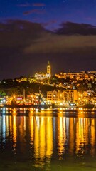 Fototapeta premium A serene nighttime cityscape reflected on calm waters (1)