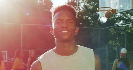 Confidence, portrait or man on basketball court with smile, fitness hobby or practice in weekend match. Pride, happy or player with flare, hoop sport and training session with athletic competition. © peopleimages.com