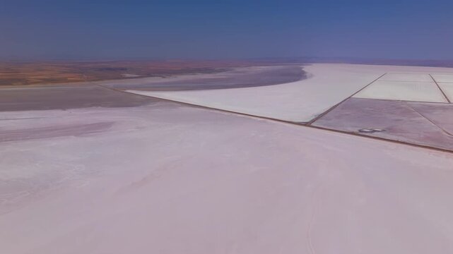 Aksaray, Turkey. Overhead drone shot of Tuz Golu salt works creating geometric patterns of pinkish ponds and straight service roads on white surface.. Aerial View