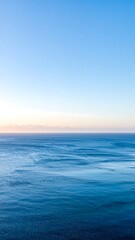Obraz premium A serene ocean view at sunrise with calm waters and clear sky