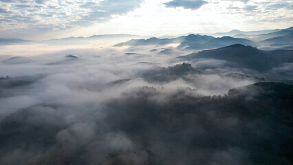 Fototapeta premium Aerial view of mountains and forest with the sea of fog before sunrise by drone