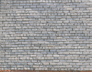 Obraz premium White brick wall with gray paint and red brick base outdoors
