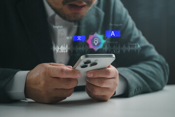 Businessman using smartphone for AI voice translation app with multilingual icons, speech recognition and sound wave for international communication, global business and language learning. © Looker_Studio