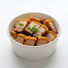 Side view of crispy roasted pork belly over white rice garnished with green onions in a paper bowl isolated on white background.