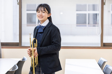 トランペットを持って微笑む女子学生