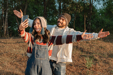 man and a woman are taking a selfie in the woods