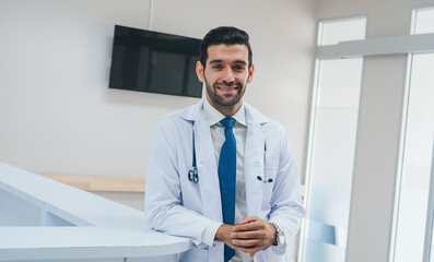 man in a white coat and blue tie is smiling for the camera