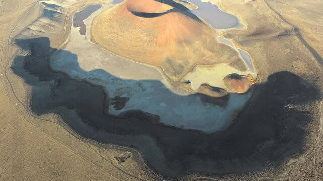 Aerial view of tuff ring cone and volcanic crater lake maar in a barren caldera of Konya Turkiye. Beautiful arid Anatolian desert terrain shows a dry geologic basin viewed from above without trees.