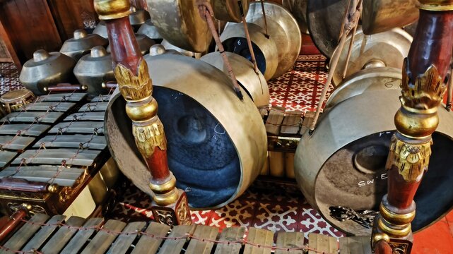 Macro style closeup of traditional gamelan instruments from Java featuring bronze gongs and metallophones, cultural music heritage, ceremonial rhythm, and classical ethnic ensemble artistry.