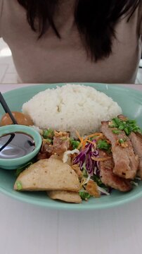 Struggling to picked marinated egg using chopsticks. Thit kho or braised pork and eggs paired with rice, goi tom or cabbage salad and cha lua or ham. Traditional Vietnamese food