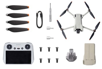 Fototapeta premium Drone kit with remote controller, foldable quadcopter, propellers, battery, charging cable, screwdriver and spare screws arranged flat lay, isolated on white background