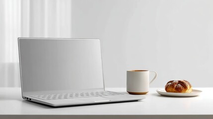 Modern laptop with coffee and pastry on a white desk, bright natural light
