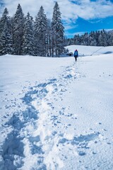 A young woman walking in the snow with a backpack