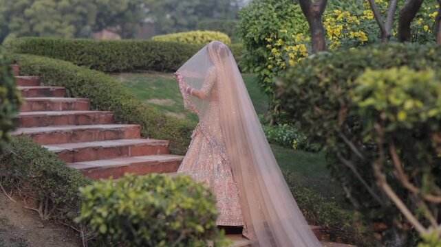 An Indian Bride Posing for Wedding Photoshoot Wearing Traditional Bridal Attire and Jewelry at her Indian Wedding