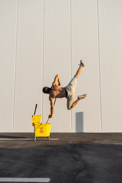 Acrobat playing with cleaning bucket and mop