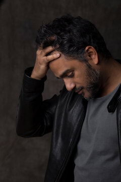 Portrait of an Indian man, holding his head