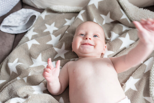 Portrait of happy baby girl lying on a blanket