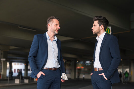 Two businessmen waiting at bus terminal