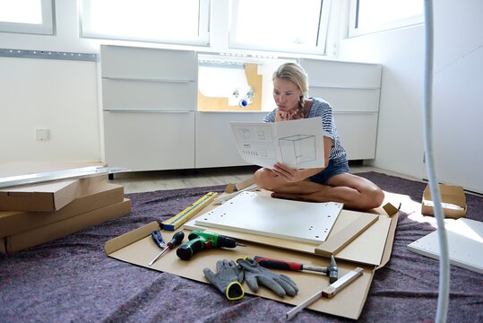 Woman reading assembly instructions at home