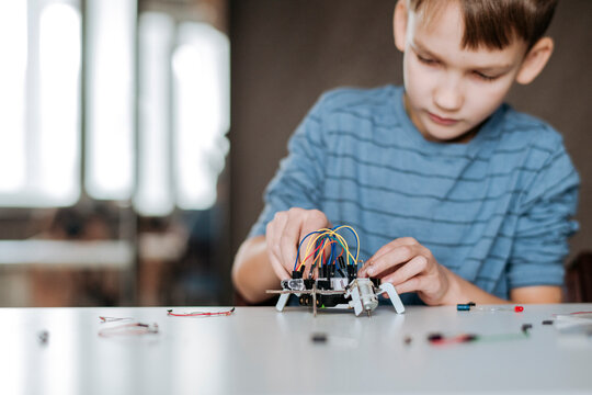 Boy assembling robot at home