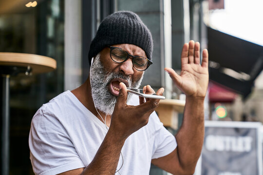 Mature businessman talking on the phone, wearing earphones
