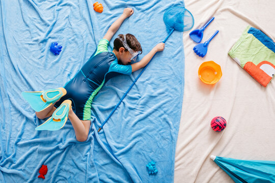Boy diving in water, beach equipment at the beach