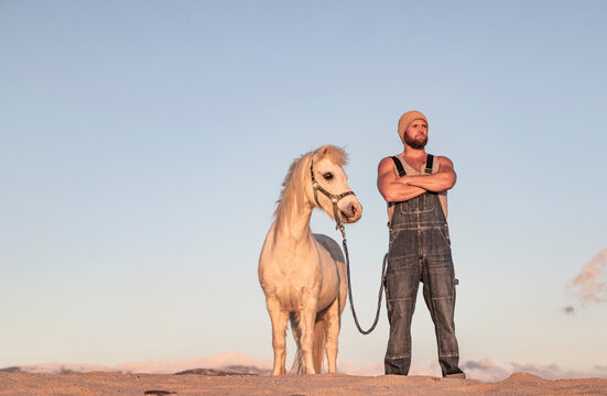 Spain, Tarifa, man with pony standing on the beach
