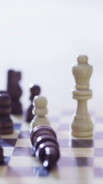 Hands, chess and checkmate with game, piece and eliminate king with strategy, play and competition in home. Person, wooden board and push toy for contest, challenge and winning match with victory