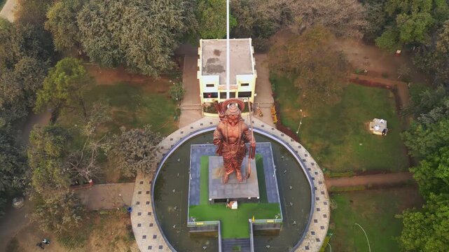 A aerial view captures the 70-ft Lord Rama idol at Tapovan in Panchavati, Nashik, standing tall beside the serene Godavari River, surrounded by lush greenery and sacred ambiance of Maharashtra