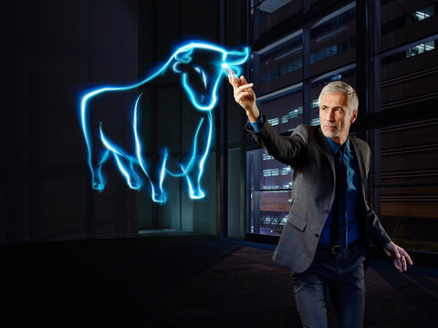 Businessman painting a bull with light
