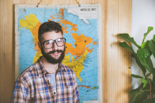 Portrait of bearded man wearing glasses in front of a map