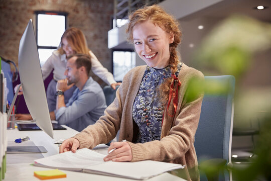 Young woman working in modern creative office, usine laptop
