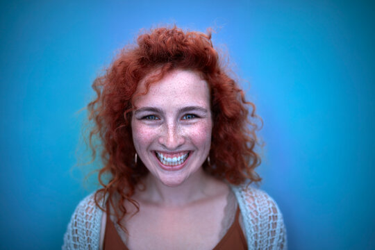 Portrait of happy young woman in blue light