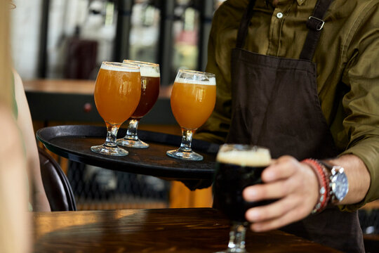 Waiter serving variety of craft beer in a pub