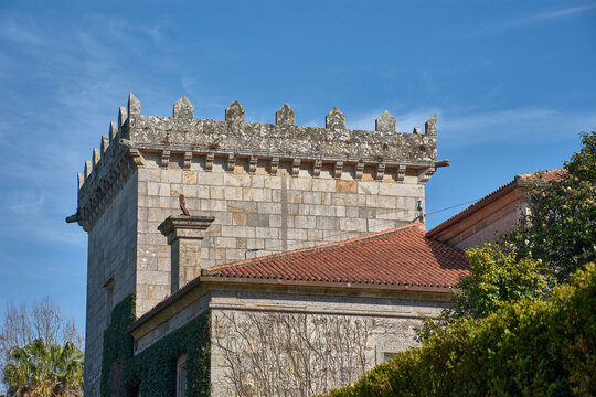 View of the Pazo de Castrelos with its crenellated tower and green gardens on a sunny day in Vigo, Spain