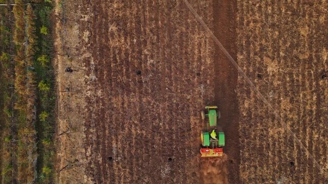 Aerial view of Adgaon, Nashik farmland during harvest, golden crops swaying farmers at work tractors moving showcasing vibrant rural life, agricultural abundance, and sprawling landscapes from above