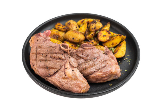 Roasted lamb rump steak with crispy golden potatoes served on dark plate, cooked sirloin saddle meat styled in rustic overhead composition..