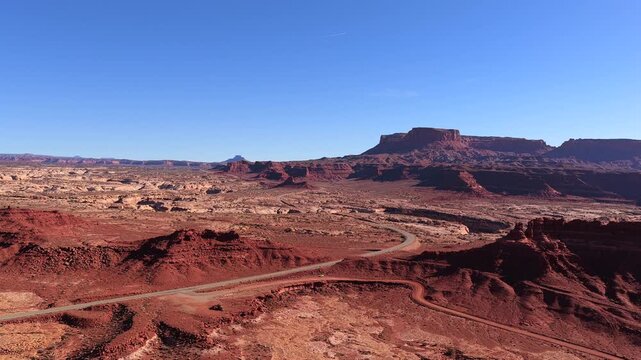 Explore the primeval scale of an eroded canyon system as the drone lowers toward the earth. The stark crimson topography provides a universal, location agnostic alien planet backdrop.
