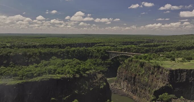 Victoria Falls Zimbabwe Aerial v7 flyover capturing historic arch bridge spanning Zambezi River between the towns, surrounded by lush natural landscape - Shot with Mavic 3 Pro Cine - Jan 3rd 2024